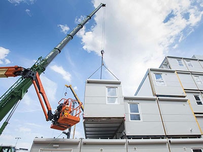 Modular Building being constructed by lifting the units on top of each other by crane. 