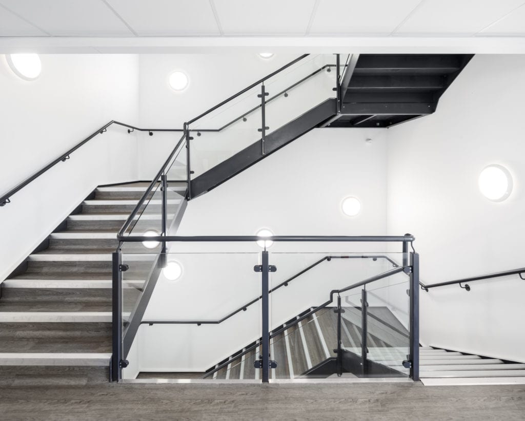 White walls and bright lights on staircase inside new modular healthcare facility.