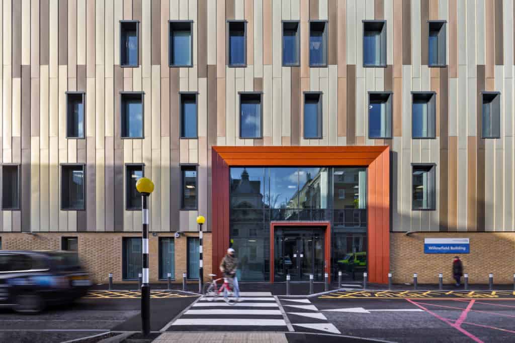 Cyclist on a zebra crossing outside of new modular hospital building for Kings College Hospital.