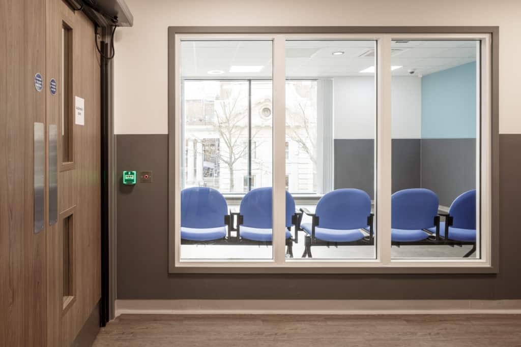 Waiting area in a modular hospital. 3 windows showing inside of a waiting area for patients.