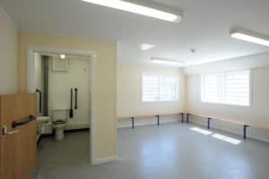 Inside view of a bathroom and empty room in a modular prison facility. 