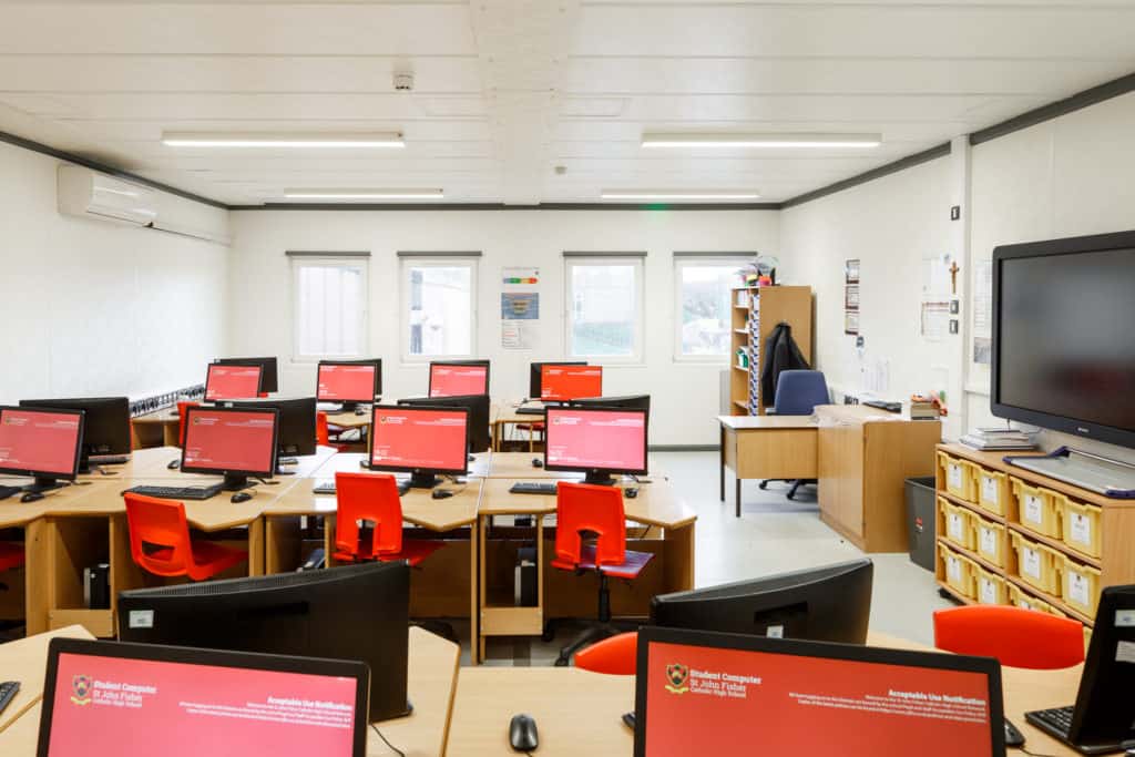 Lots of computers on desks next to each other. Digital facilities inside the temporary classrooms.