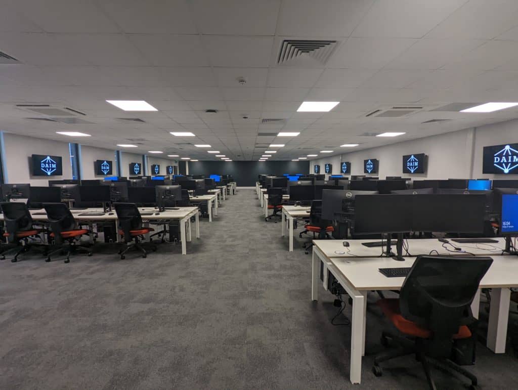 Inside view of the modular classroom created for Hull University. Rows of desks with PC's and desk chairs. 