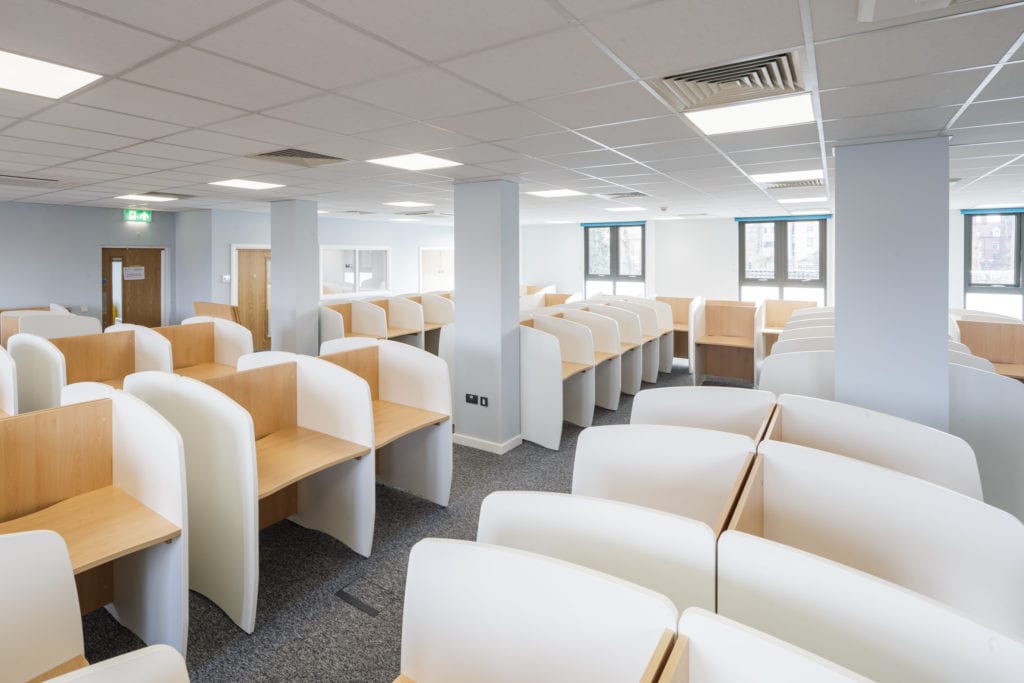 Inside a modular classroom, desks with dividers for private learning.