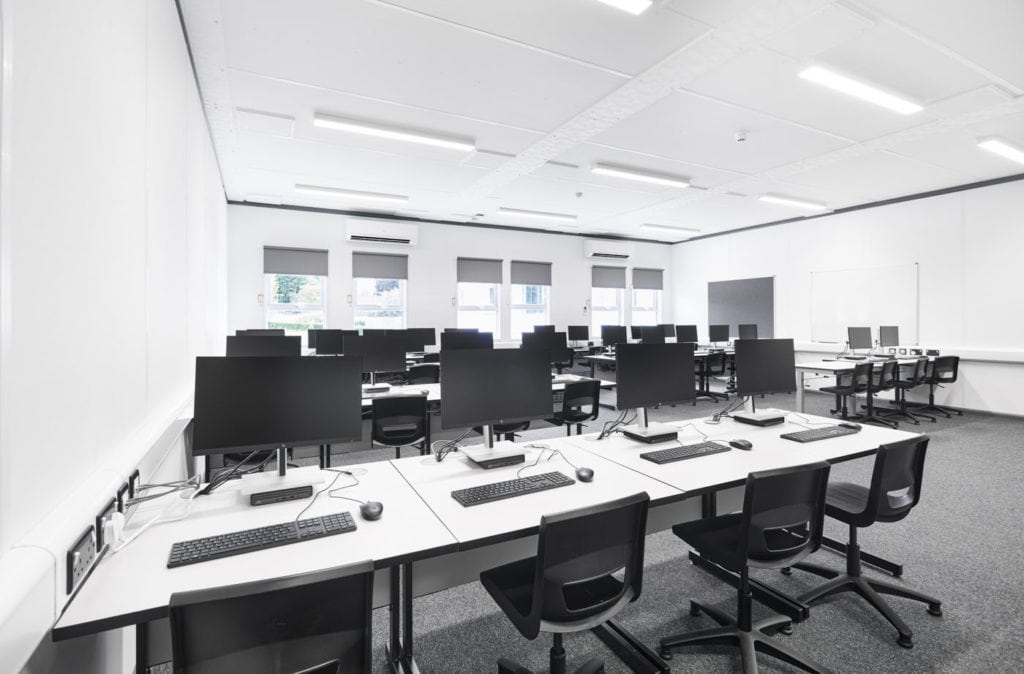 Modular classroom filled with desk and computers.