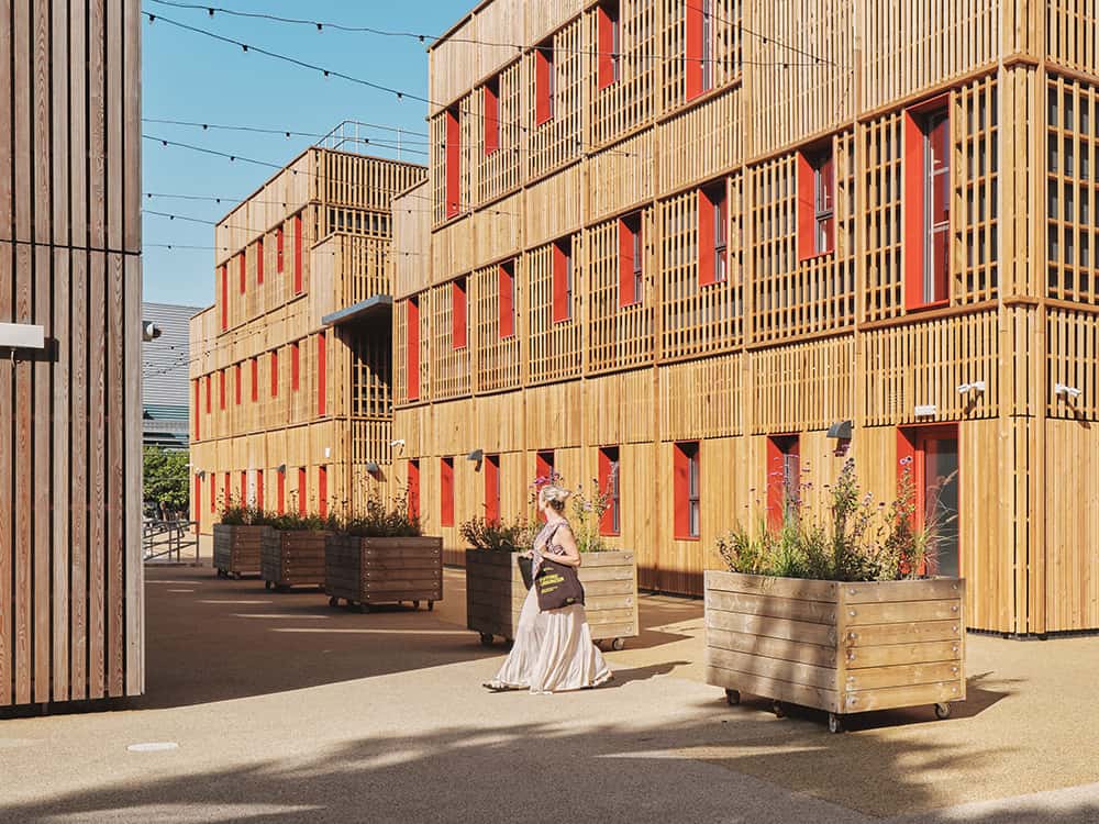 A woman walking on the campus of The Paper yard, temporary modular structure. 