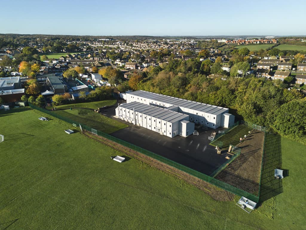 Bradsfield Academy. Full view of the entire modular school building, surrounded by a field. 