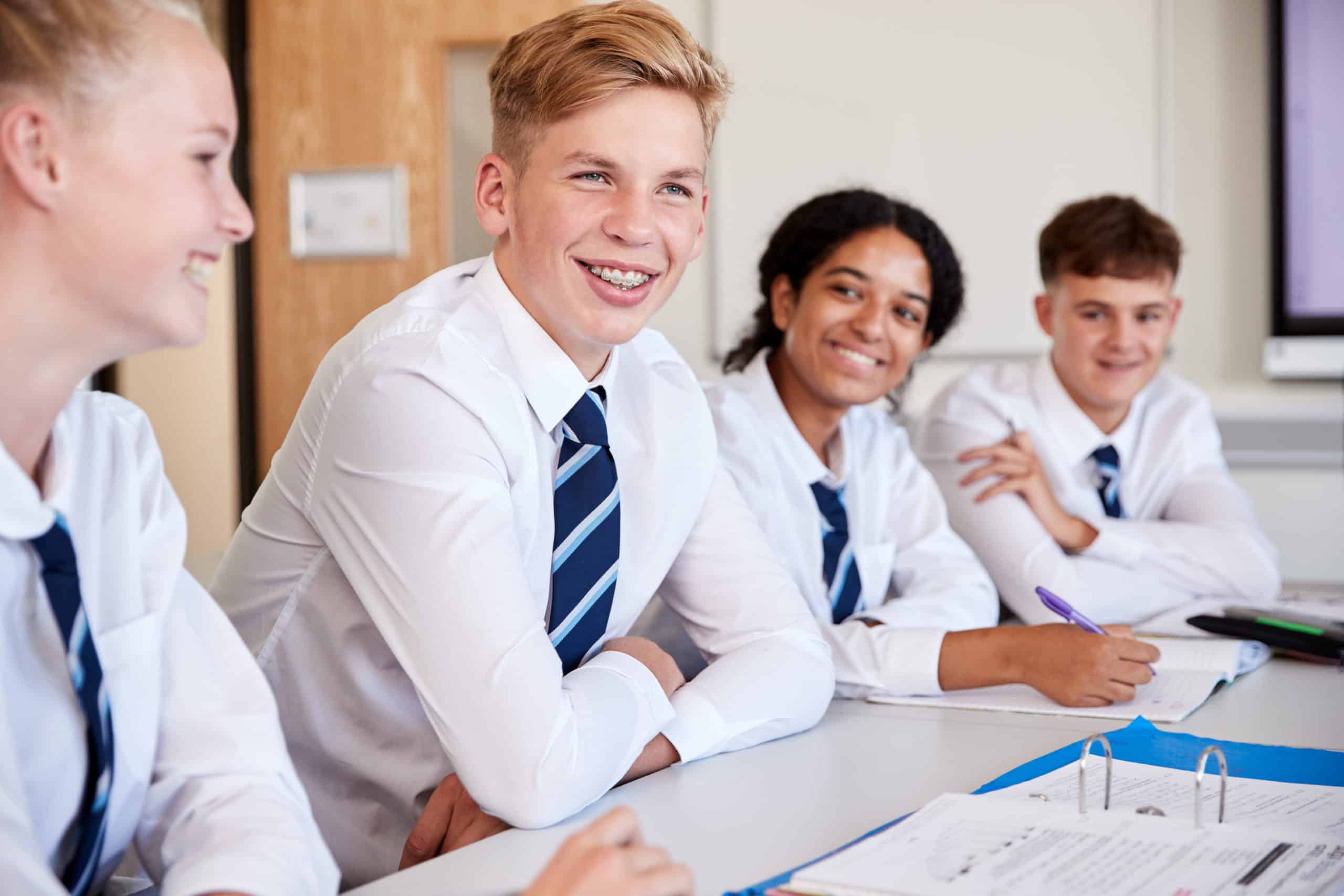 Line,Of,High,School,Students,Wearing,Uniform,Sitting,At,Desk
