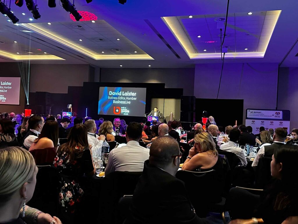 David Laister Business Editor for Humber Business Live stood in front of a crown giving a speech at the business Awards.